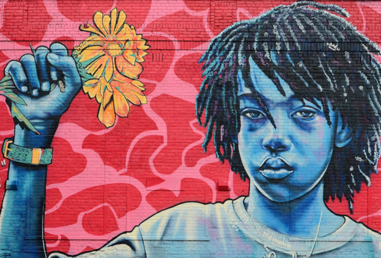 mural painting of teen holding flower against a red colored background